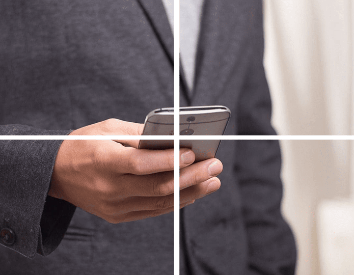 A man in a suit holding a cell phone.